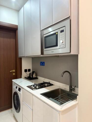 a kitchen with a microwave and a stove and a sink at Aswar Plus in Tabuk