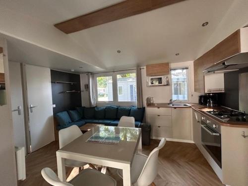 eine Küche und ein Wohnzimmer mit Tisch und Stühlen in der Unterkunft Camping bois Dormant, 4 étoiles 85 st jean de mont in Saint-Jean-de-Monts