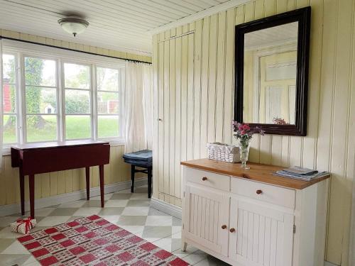 Una habitación con una cómoda, un espejo y un piano. en 4 person holiday home in BJÖRKÖ-By Traum, en Björkö