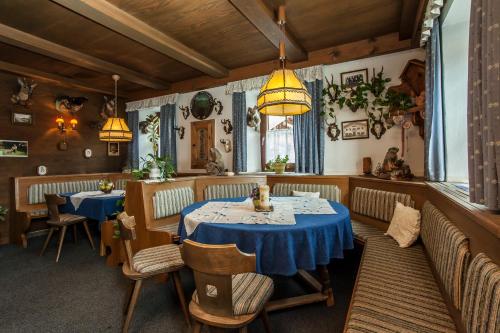 una sala da pranzo con due tavoli, sedie e luci di Kaiserpension Müllnerhof a Oberndorf in Tirol