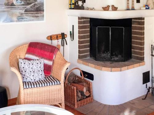 a living room with a chair and a fireplace at 5 person holiday home in TYRESÖ in Tyresö
