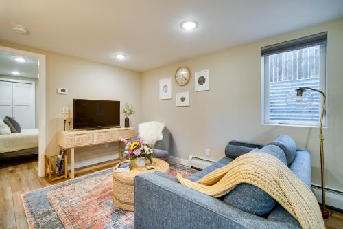 a living room with a blue couch and a tv at Alluring Anchorage Apt - Walk to Coastal Trl! in Anchorage