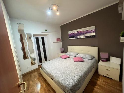 a bedroom with a bed with pink pillows at La Casetta di Andrea e Alessandra in Rocca di Papa