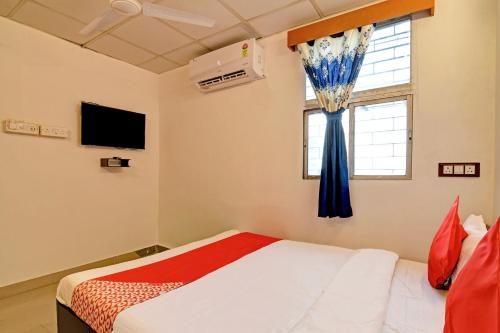 Un dormitorio con una cama y una ventana con cortinas azules. en Hotel O Jalan Regency, en Calcuta