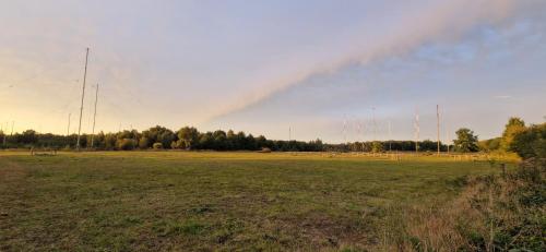 a rainbow in the sky over a field at Bos-en-Veld in Wingene