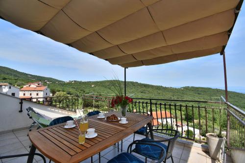 a wooden table and chairs on a balcony with a view at Apartment Mario in Martina