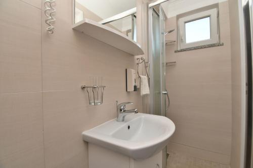 a white bathroom with a sink and a shower at Apartment Mario in Martina