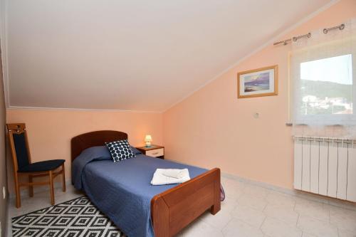 a bedroom with a bed and a chair and a window at Apartment Mario in Martina