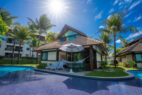 a villa with a hammock and a swimming pool at Bangalô c/ Piscina - Marulhos Resort, Beira Mar de Muro Alto / Porto de Galinhas in Porto De Galinhas