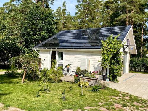 a small white house with solar panels on the roof at 4 person holiday home in BORGHOLM in Borgholm