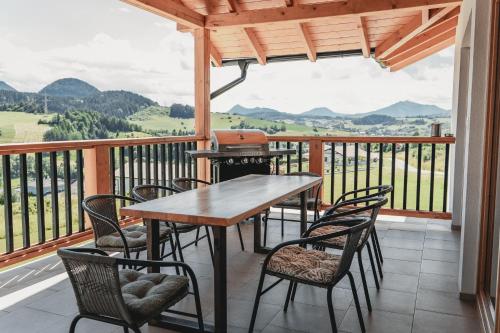 a table and chairs on a balcony with a view at Chata Pod Skalkami in Dolný Kubín