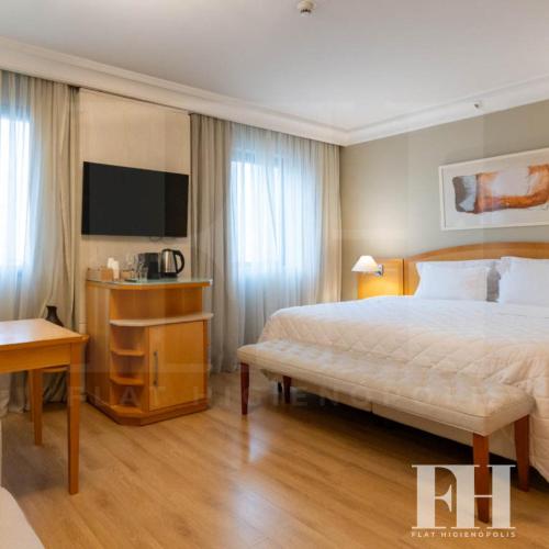 a hotel room with a bed and a television at Flat Higienópolis in Sao Paulo