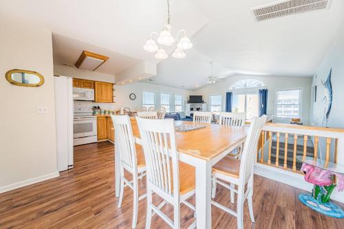 a kitchen and dining room with a wooden table and chairs at Ocean View's in Kill Devil Hills