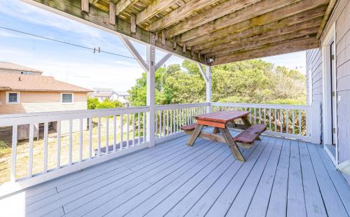 a wooden porch with a picnic table on a deck at Ocean View's in Kill Devil Hills