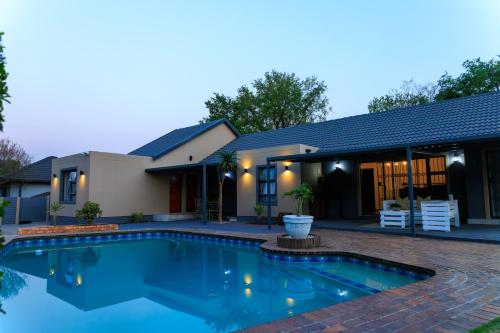 a swimming pool in front of a house at Hamisi Manor Guest House in Midrand