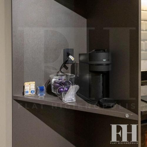 a counter top with a coffee maker and a coffee pot at Flat Higienópolis Premium in Sao Paulo