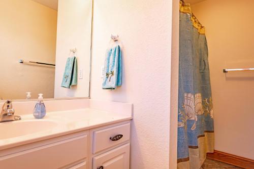 a bathroom with a sink and a mirror at On Island Time in Kill Devil Hills