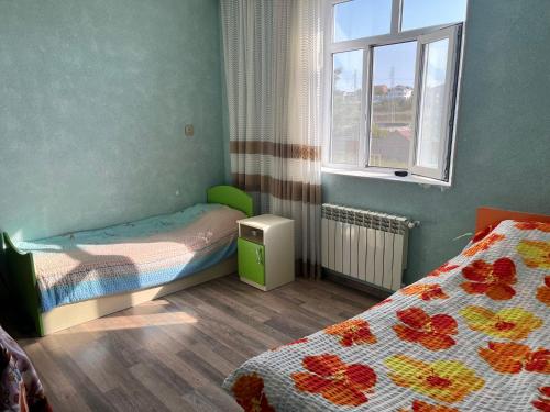 a small room with two beds and a window at Dubendi resort villa in Baku