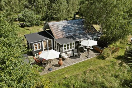 an aerial view of a house with a deck and umbrellas at Wooden House With Wild Garden By Sejerø Bay in Kalundborg