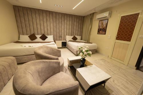 a hotel room with two beds and two chairs at The Muse Luxury View Hotel in Cairo