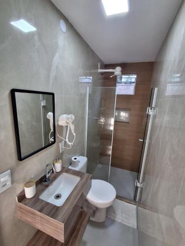 a bathroom with a toilet and a shower and a sink at Pousada Vila Praiana in Arraial do Cabo