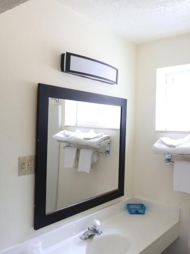 a bathroom with a mirror and a sink at Downtown Inn in Albuquerque