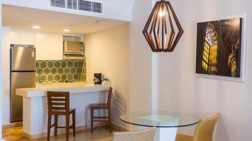 a small kitchen with a glass table and chairs at Luna Palace in Mazatlán