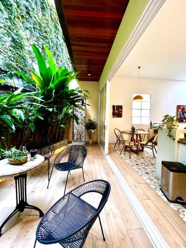 a patio with chairs and a table and a plant at Casa Rambla Serra Cali in Cali