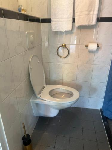 a bathroom with a toilet and towels on the wall at Hotel-Eetcafé d'Olde Heerd in Balkbrug