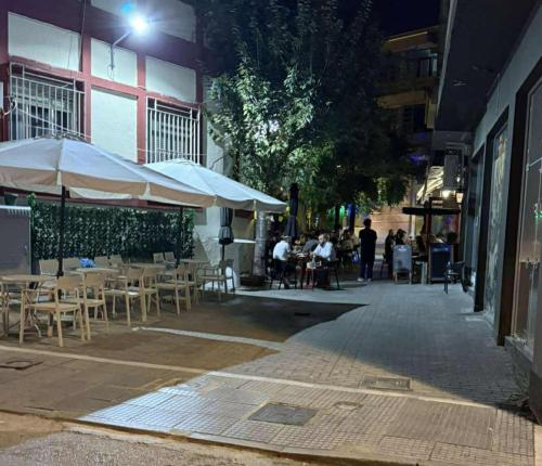 a group of tables and chairs with umbrellas on a street at Αικατερίνα in Kozani