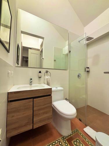 a bathroom with a toilet and a sink and a shower at Casa Rambla Serra Cali in Cali