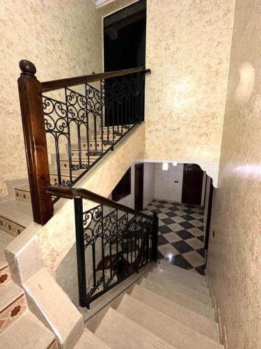 a staircase with a metal railing and a checkered floor at Villa Sultan - Private pool with no neighbors in Marrakech
