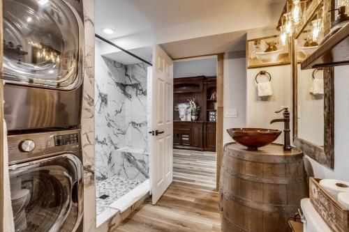 a bathroom with a washer and dryer and a wooden bowl on a barrel at Luxury Spacious House Great For A Family Retreat in Loveland