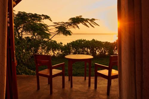 a table and chairs on a porch with a view of the ocean at Kidoti Bay in Kidoti
