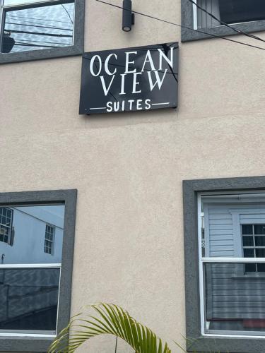 a sign for an ocean view suites on the side of a building at Down Town in Saint Georgeʼs
