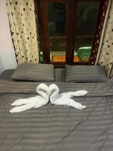 a pair of white gloves laying on a bed at Koh Samed Lung Dam Hutbeach in Ao Phutsa