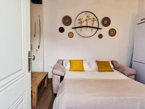 a bedroom with a bed with yellow pillows at Loft Alegría de Jerez in Jerez de la Frontera