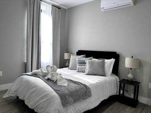 a white bedroom with a bed with a towel on it at Spacious Modern 1 Bedroom RARE Apt w GYM in Albany