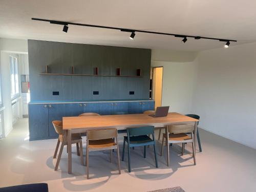 a dining room with a table and chairs with a laptop at CoLiving Steinmaur in Dielsdorf