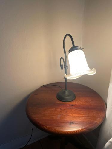 a lamp sitting on top of a wooden table at Charming Nordic Home in Central Älmhult in Älmhult