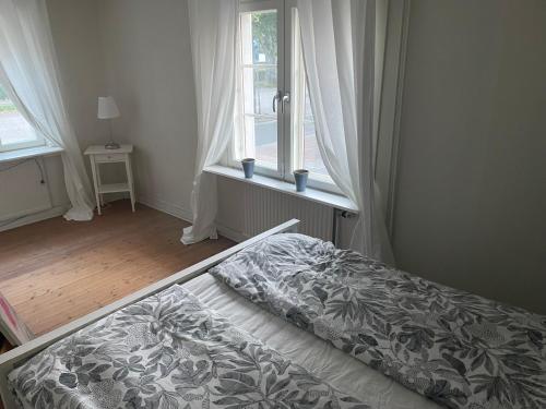 a bed in a room with a window and a bedspread at Charming Nordic Home in Central Älmhult in Älmhult