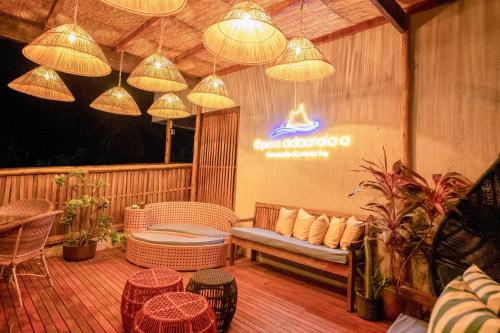 a patio with a couch and chairs and lights at POUSADA ATALAIA NORONHA in Fernando de Noronha
