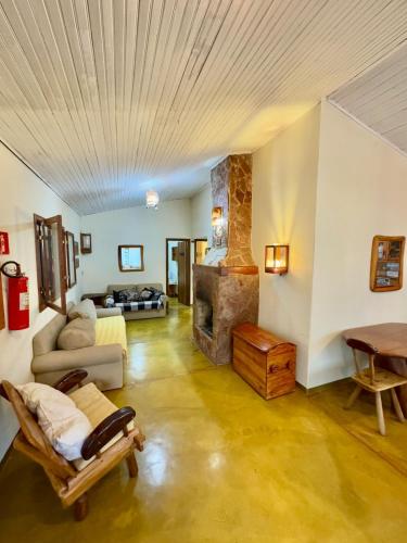a living room with a couch and a fireplace at Pousada Loquinhas in Alto Paraíso de Goiás
