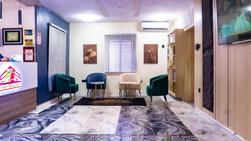 Una sala de espera con tres sillas y un pasillo. en H3 Hotel and Events Centre, en Abeokuta