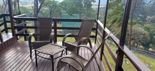 two chairs and a table on a balcony with a view at Recanto do Divino in Palhoça