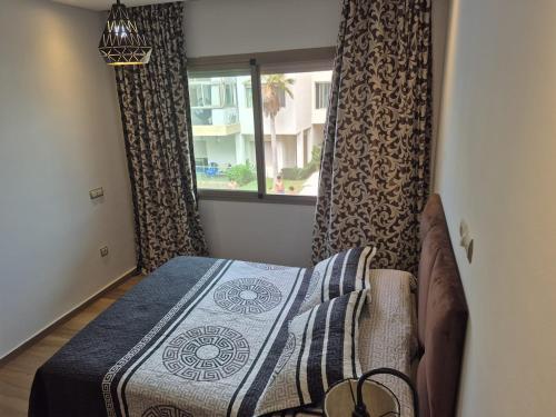 a bedroom with a bed and a window at Appart pour Famille balnéaire Accés direct à la Mer in Sidi Rahal