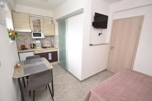 a small room with a table and a bed and a kitchen at apartmaji LEJARDIN in Škofljica
