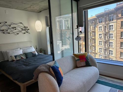 Un dormitorio con una cama y un sofá y una ventana. en Serif, en San Francisco