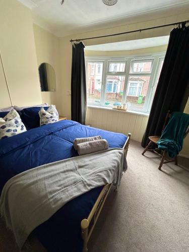 a bedroom with a blue bed and a window at Restful nights in Southampton