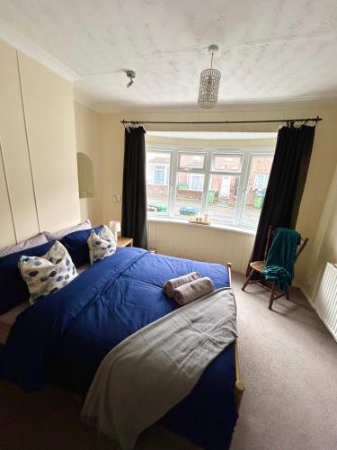 a bedroom with a blue bed and a window at Restful nights in Southampton